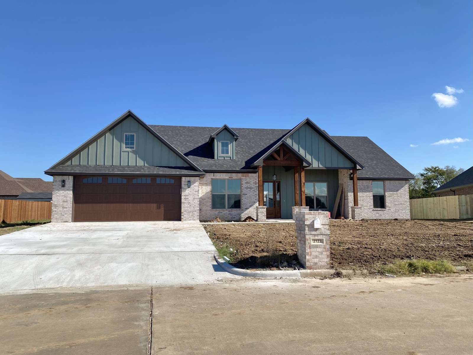 new home with brick and green roof residential construction near my location | GPS: 33.043058, -95.334123